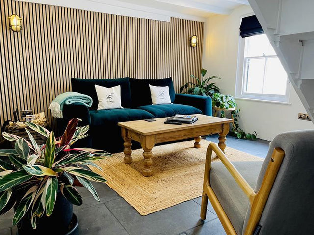 A living room with wood-panelled wall and plants