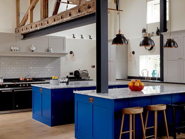 A modern kitchen with hanging industrial pendants
