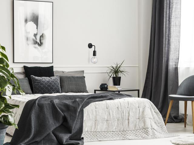 A modern bedroom decorated with black, white and grey tones
