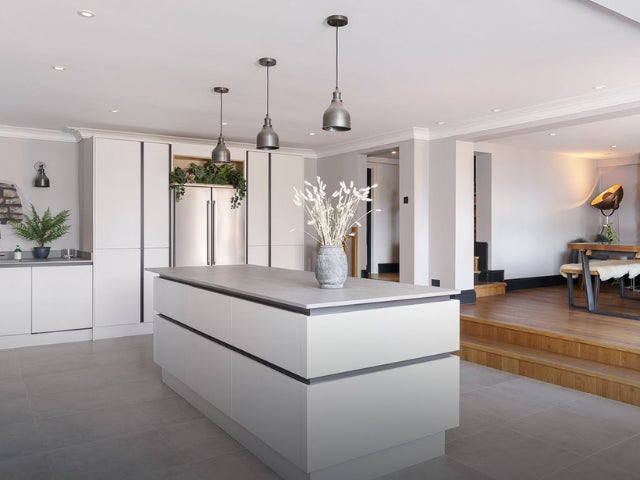 A modern kitchen and dining room space with pendant lights.