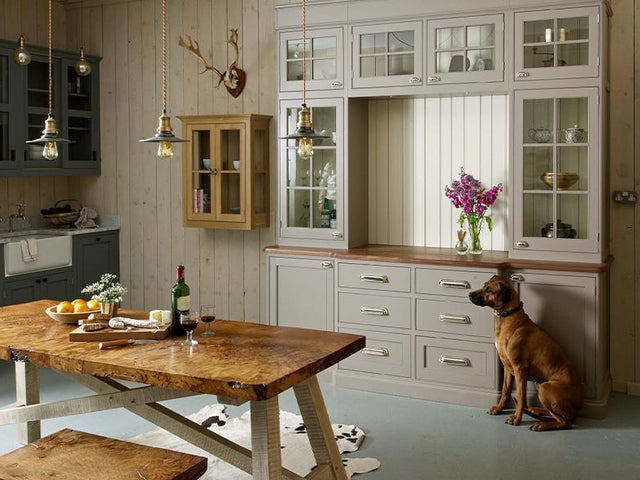 Neutral coloured kitchen interior with dog and trio of flat industrial pendants