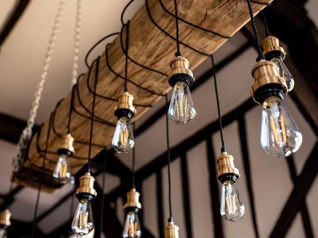 Exposed bulbs hanging over a wooden beam