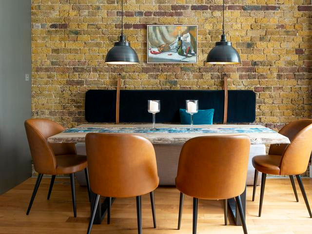 Brown chairs surrounding a table with handing dining room pendant lights