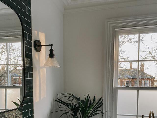 A glass funnel wall light in a bathroom