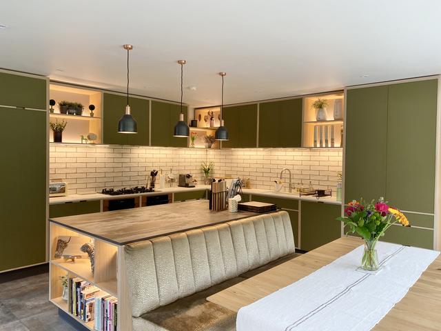 A green kitchen with a mixture of task lighting and accent lighting. 