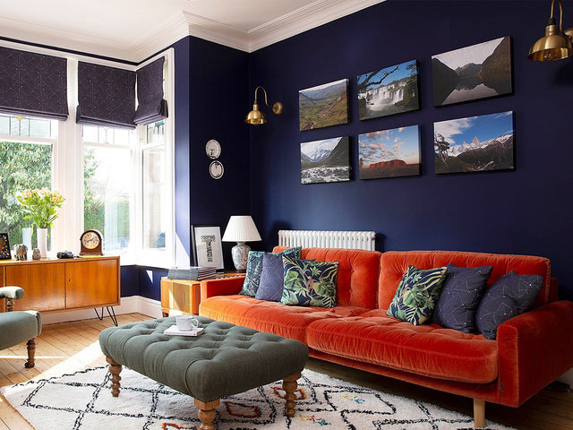 A contemporary living room with dark blue wall and brass lighting