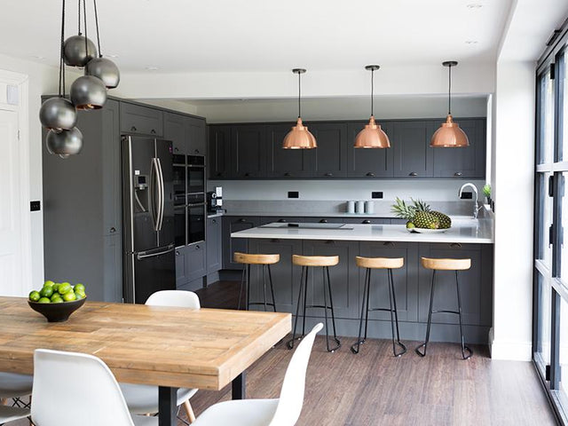 Grey open-plan kitchen interior with industrial lights